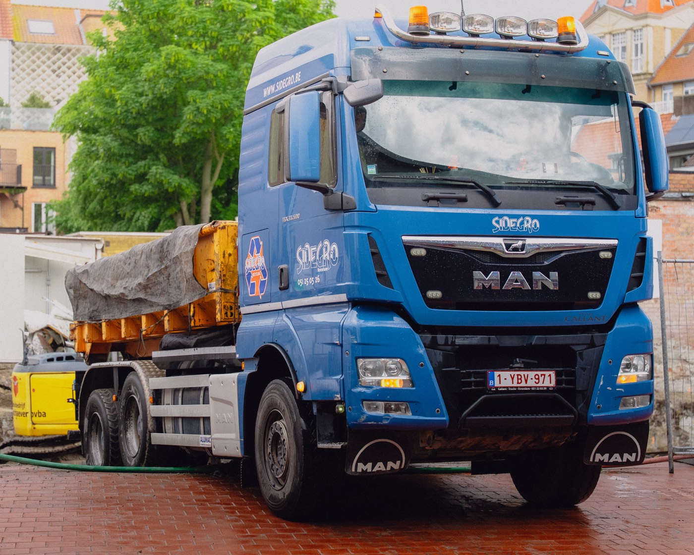 Sidegro-vrachtwagen op een dorpsplein